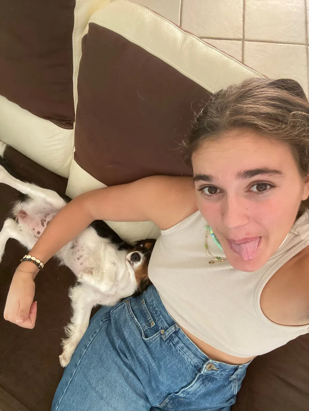 Kelly allongée sur un canapé avec un chien endormi contre elle